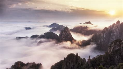  黄山 brushes with misty clouds and ancient pines for breathtaking vistas!